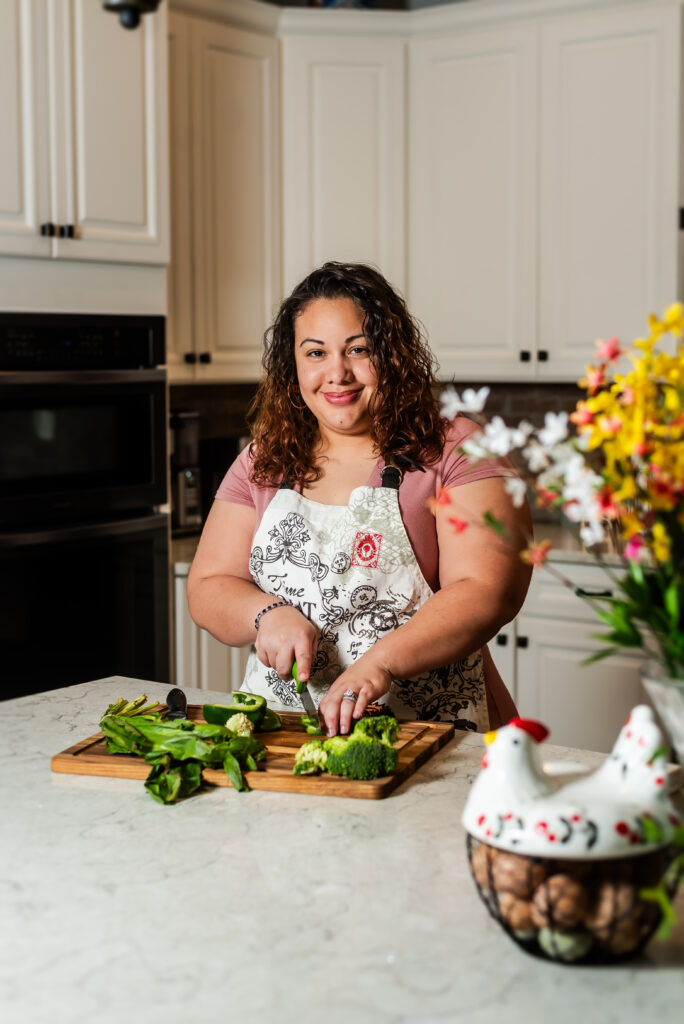 Picture of the blog writer in her kitchen cutting vegetables
